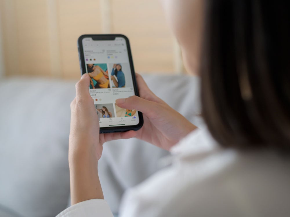 Woman scrolling a shopping site on her phone.
