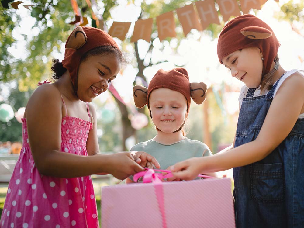 Kids opening a present at a birthday party.
