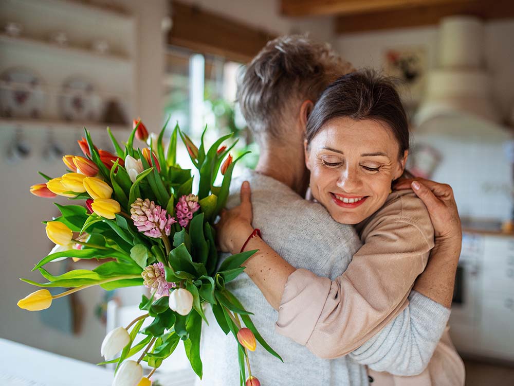 Woman giving a friend sympathy flowers
